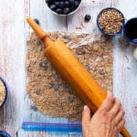 A rolling pin over a ziploc bag crushing the bran cereal
