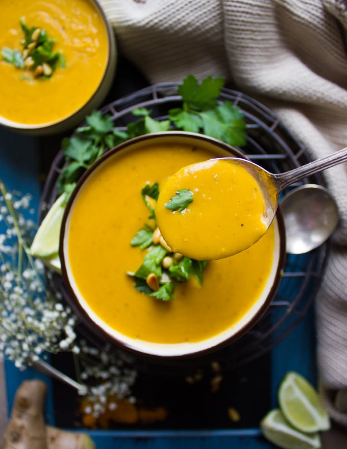 A spoon showing sipping some butternut squash soup recipe over a bowl of healthy butternut squash soup recipe