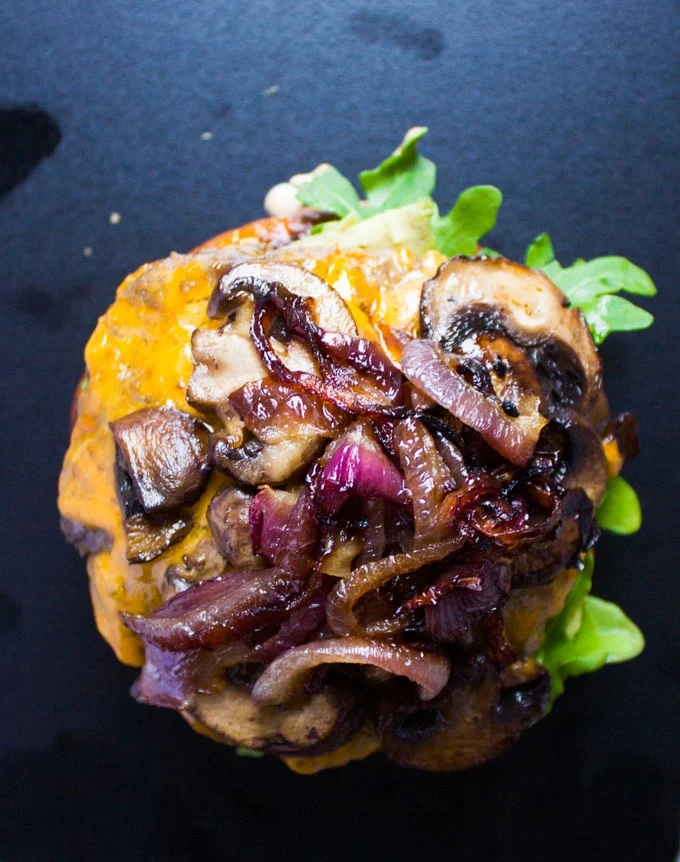the stuffed burger over the bun and topped with mushrooms and onions