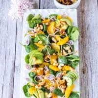 Top view of a large plate of an orange salad with orange dressing