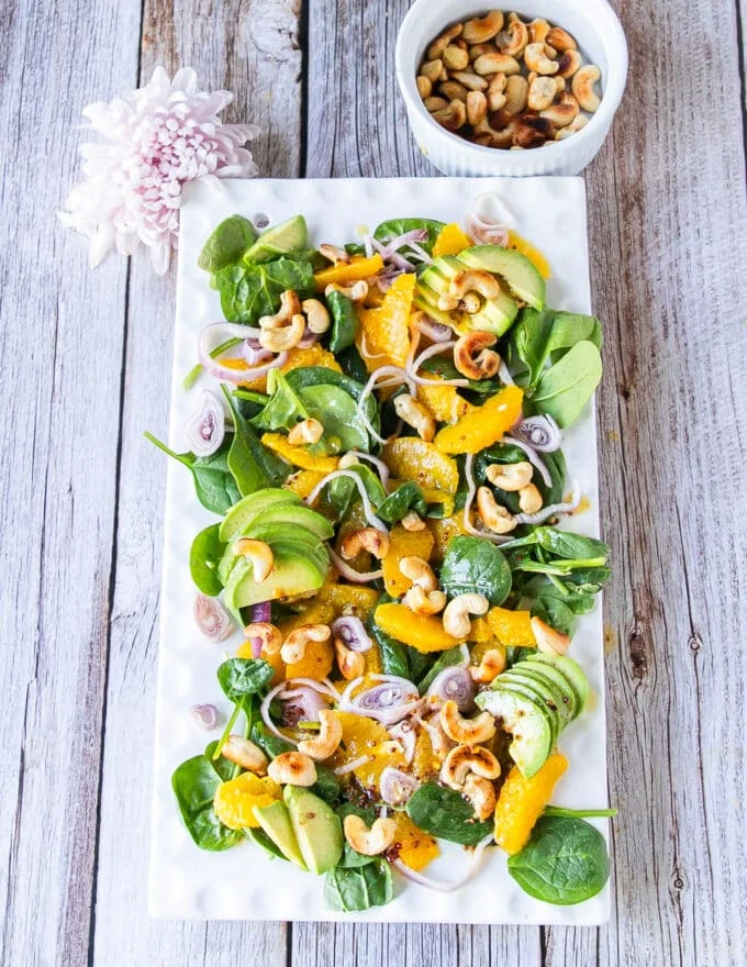 Top view of a large plate of an orange salad with orange dressing