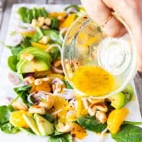 orange dressing is poured over the orange salad