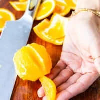 A hand holding a segmented orange showing how it should look
