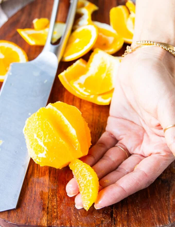 A hand holding a segmented orange showing how it should look