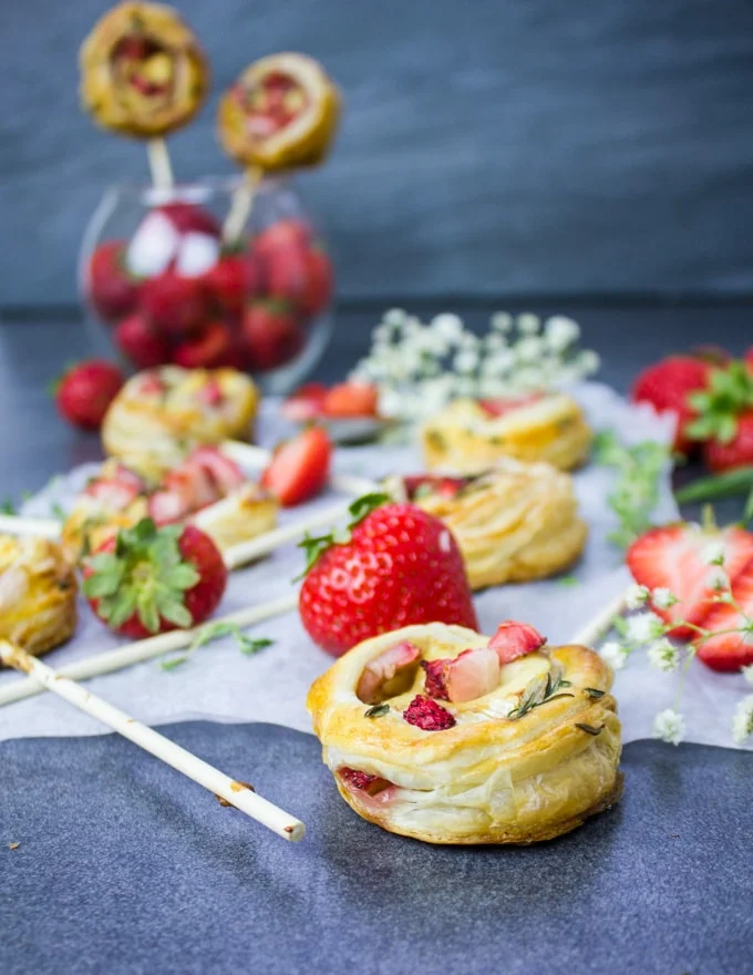 A few strawberry savory hand pies on a baking paper over a great board.