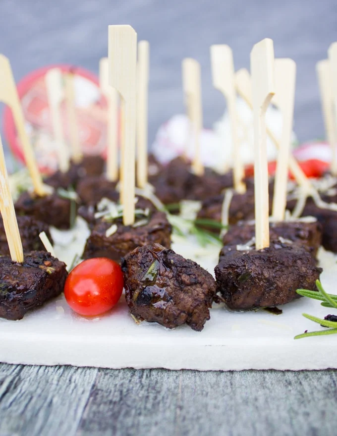 Close up of a steak bite on a stick and a piece of tomatoe