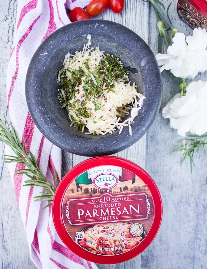 A mortar and pestle showing soft butter, herbs and Parmesan cheese