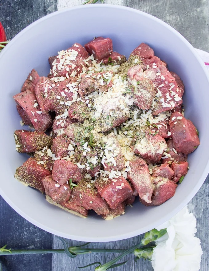 Raw steak cut into cubes and seasoned
