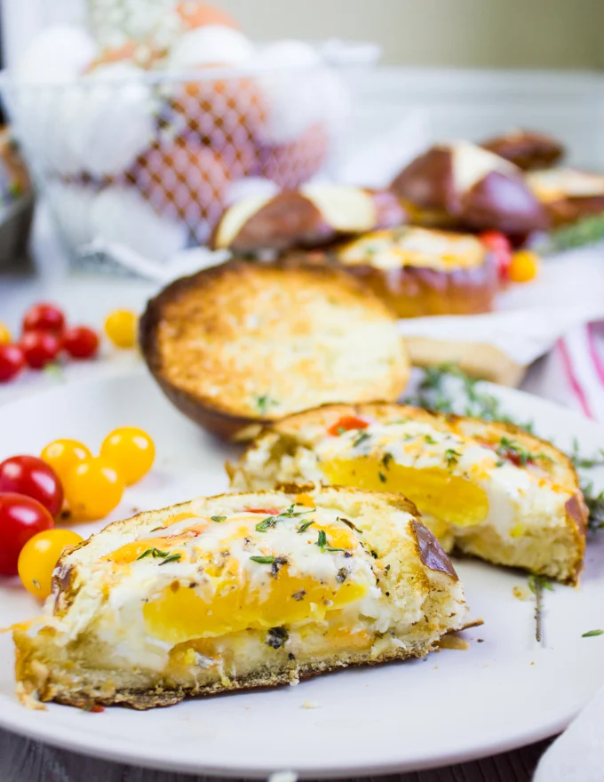A baked egg in bread bowl cup up shoing the egg yolk and fully cooked eggs