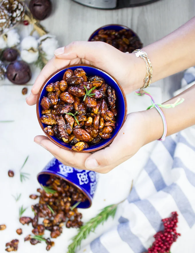 A hand holding a bowl of nuts up and close