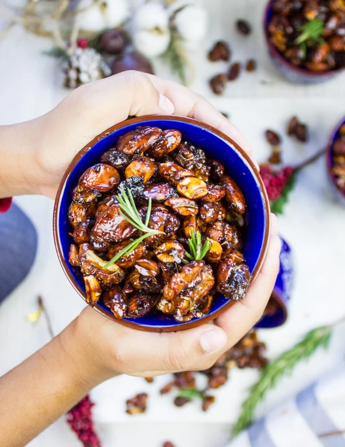 A kids' hand handing over some spiced mixed nuts to share