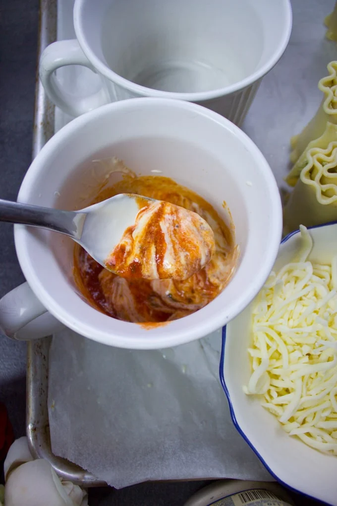 A spoon swirling the sauces to make a rosa sauce