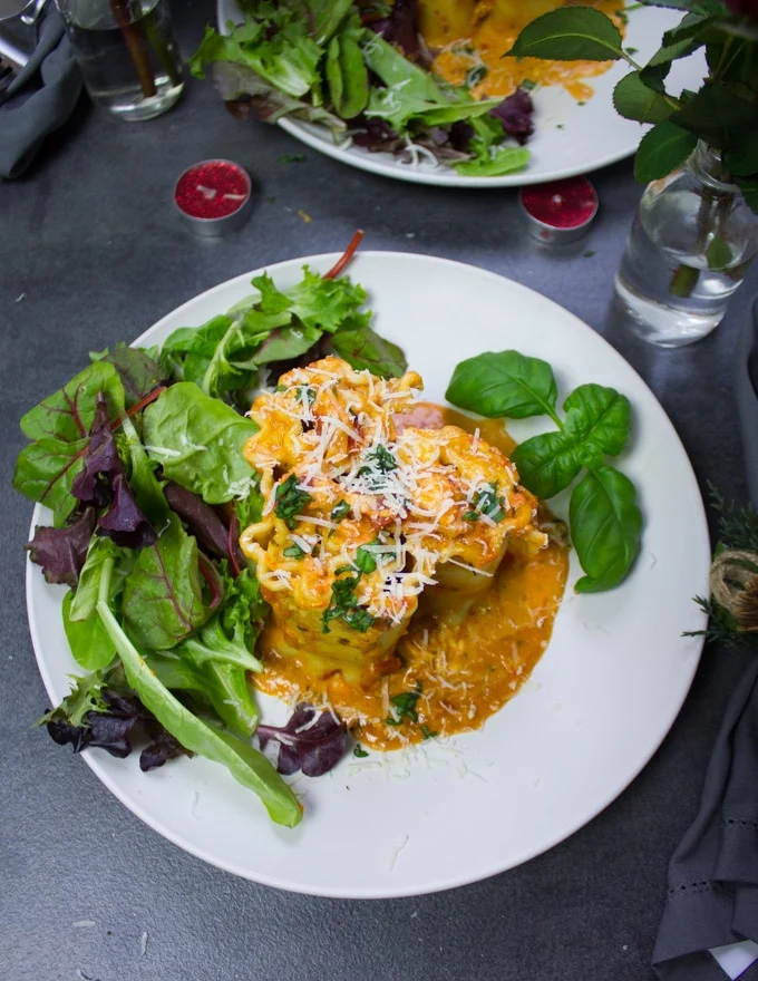 A finished lasagna roll ups plate with salad on the side