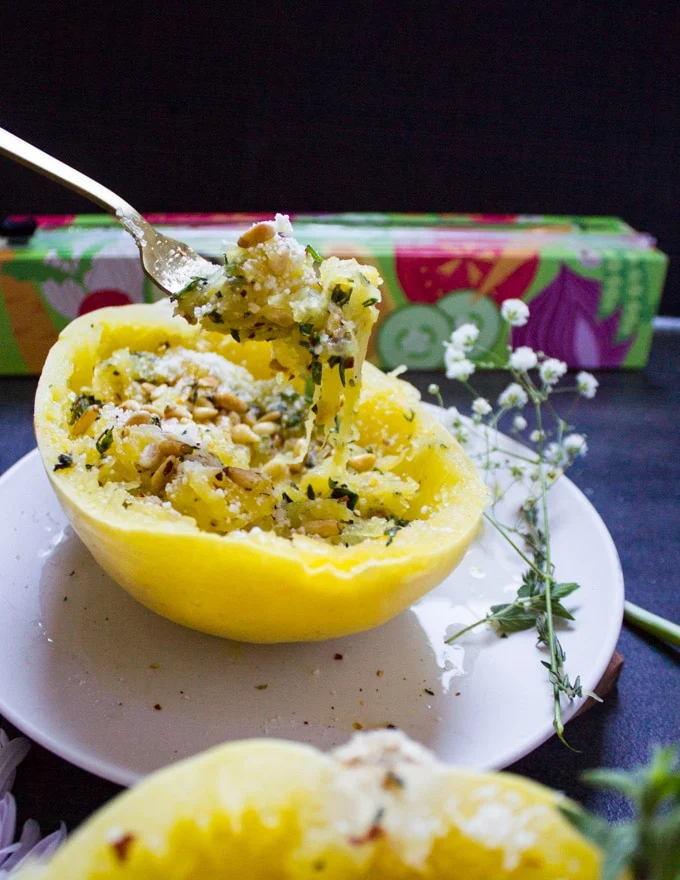 A fork lifting up the spaghetti squash strands to show the texture and topping of spaghetti squash recipe
