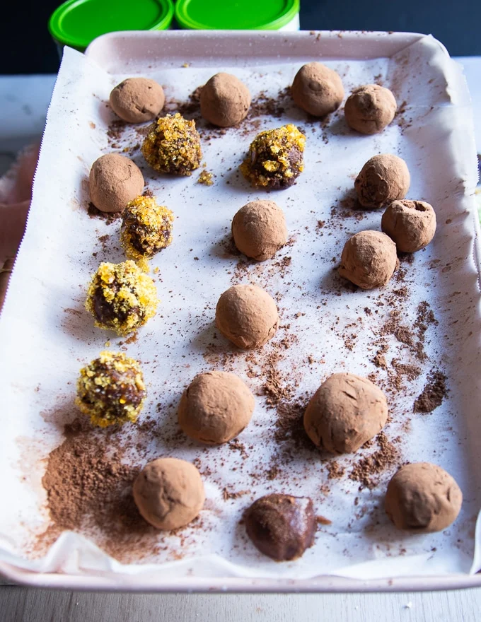 chocolate truffles on a parchment baking sheet ready and coated for chilling