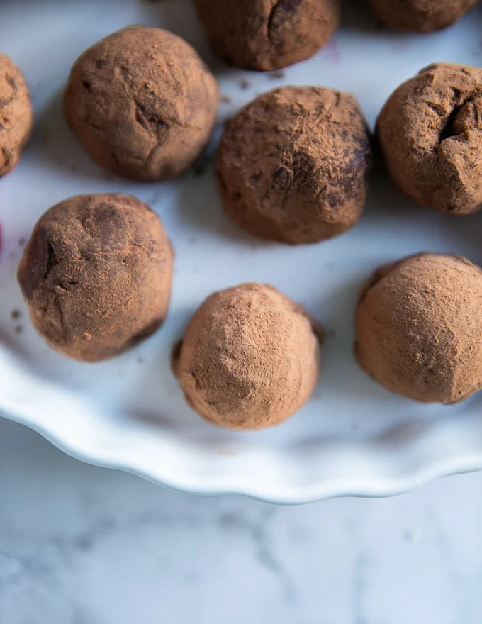 close up of a single chocolate truffle on a white plate