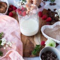 A hand holding a jar of hot heavy cream