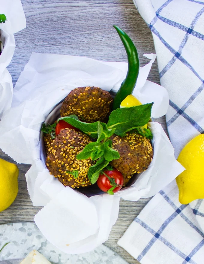 three falafels in a bucket with fresh mint
