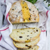 A whole loaf of bread sliced up on a kitchen towel