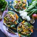 3 thai salad plates surrounded by a towel, white tulips, fresh mint