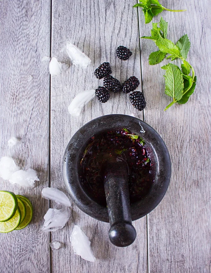 The blackberries crushed into puree in the mortar and pestle