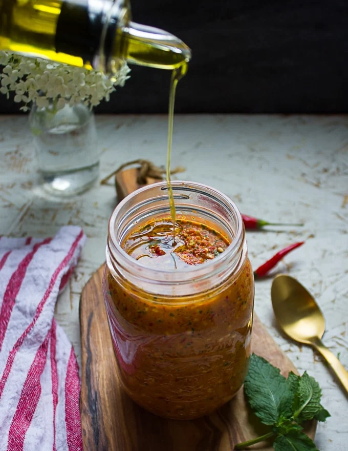 The sauce placed in a mason jar and then drizzled with olive oil