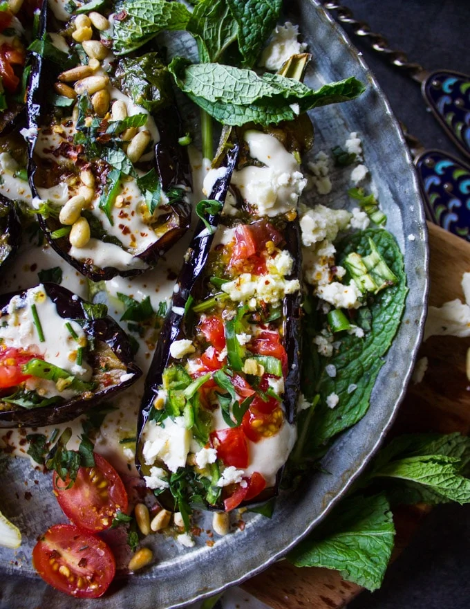 fried Eggplant topped with tahini, tomatoes, feta and green chillies on a bed of tahini sauce