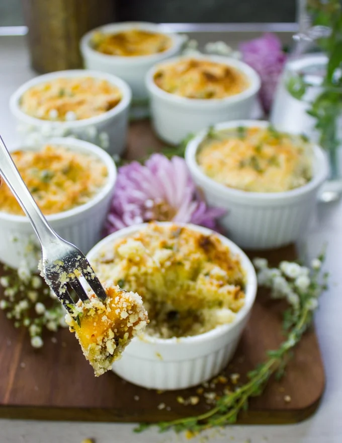 A fork holding a sweet potato from the gratin showing the sweet potato coated with the crunchy topping