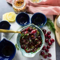 A spoon holding off the ready cherry salsa to show the texture of it