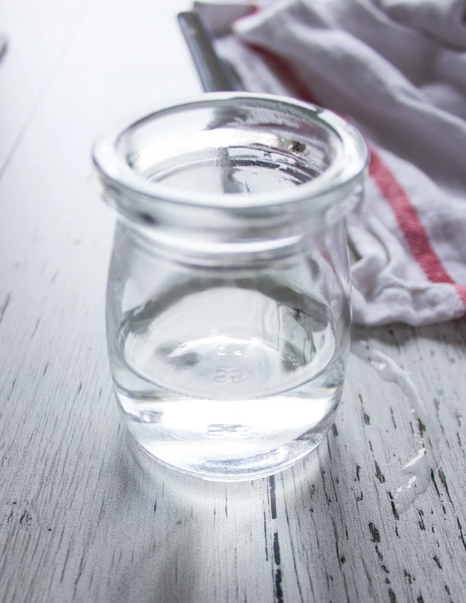 A small jar with two teaspoons of water