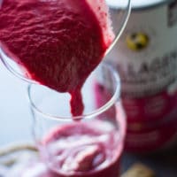 a jar pouring the cherry smoothie layer at the bottom of the smoothie cup