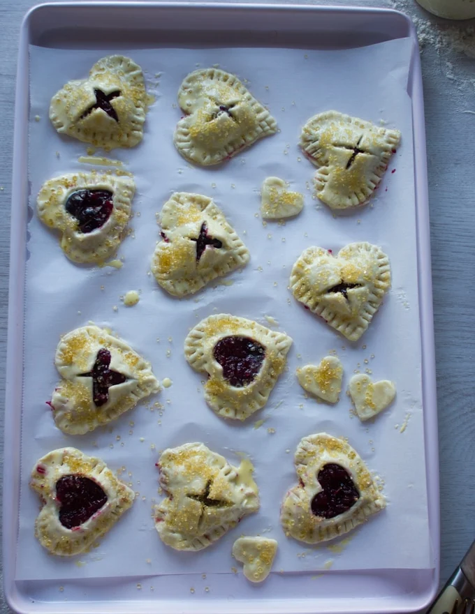 A tray of mini cherry pies going into the oven