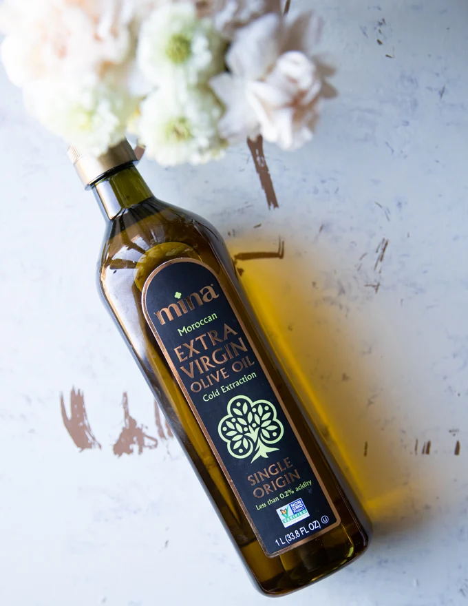 One bottle of moroccan olive oil surrounded by flowers