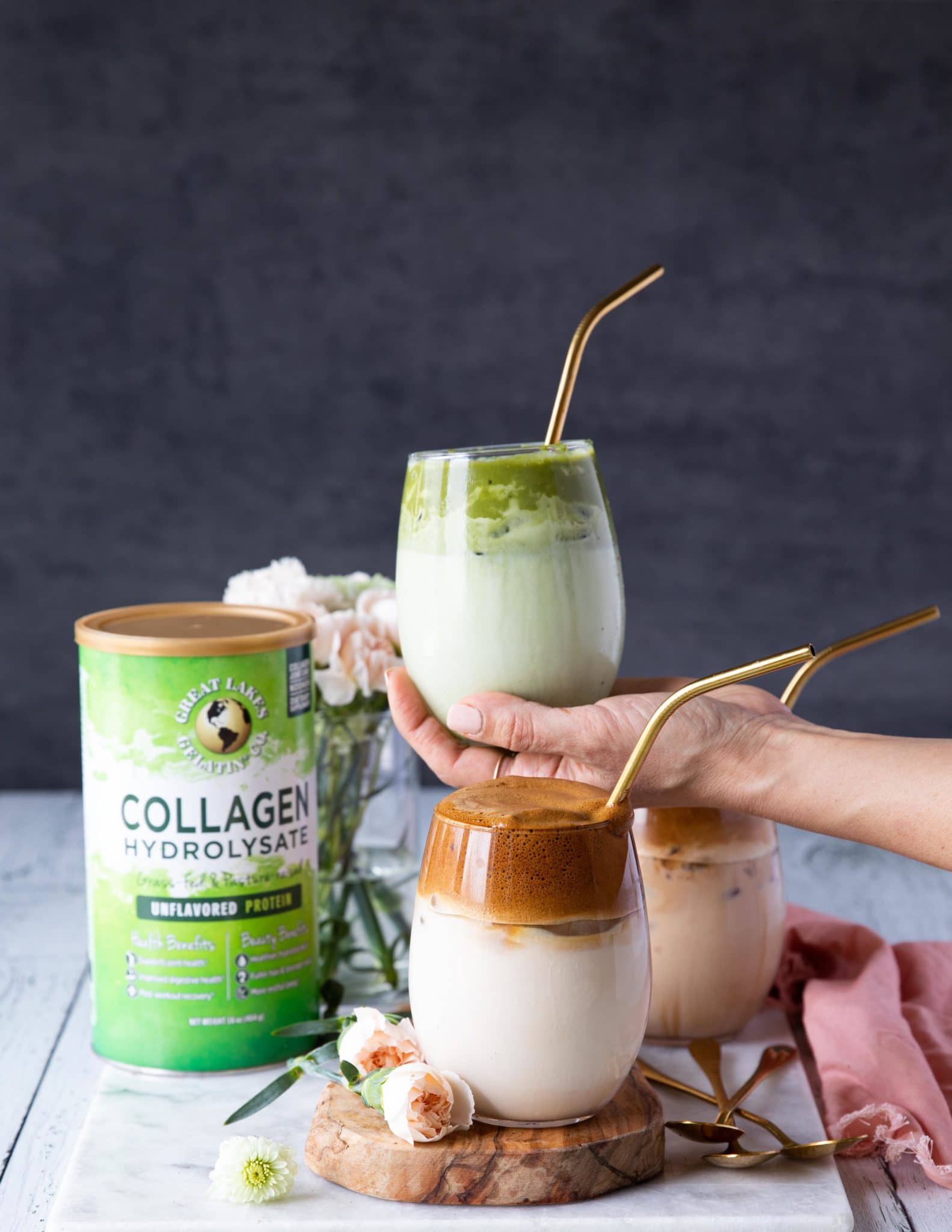 A hand holding a cup of matcha dalgona