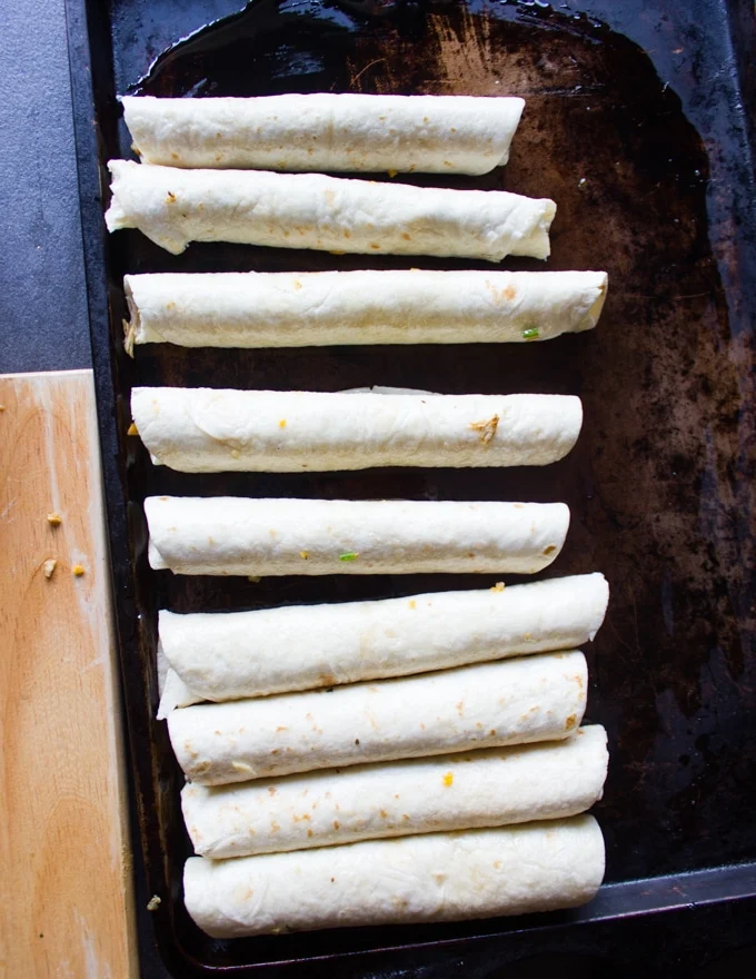 rolled out chicken flautas on an oiled baking sheet ready to go in to the oven