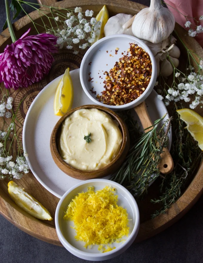 lemon garlic butter sauce or garlic butter sauce for seafood in a bowl surrounded by chilli flakes and lemon zest