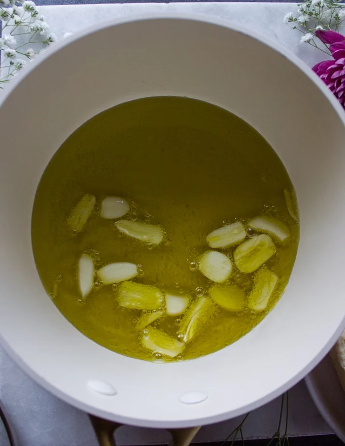 Sliced garlic in olive oil going to cook on the stove