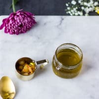 Strained olive oil in a jar and the cooked garlic separately ready to make the sauce