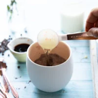 A tablespoon of oil being added to the mug using a tablespoon