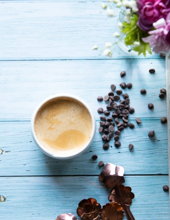 a cup of espresso surrpunded by chocolate chip to make coffee brownie in a mug