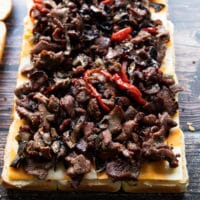 layered cheese and the grilled philly cheesesteak meat and veggies over the bread