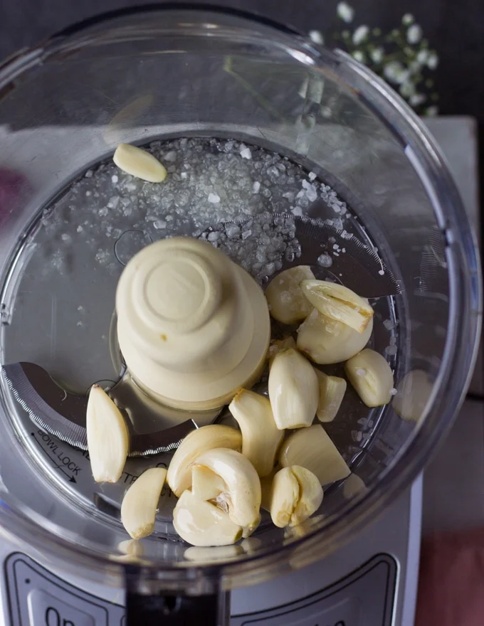 Making the garlic sauce in a food processor there's garlic and salt to begin