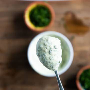 A spoon holding off tartar sauce close up showing the creamy texture of the sauce