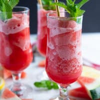 one cup of watermelon slushie close up showing the frozen and soft parts of the slushie