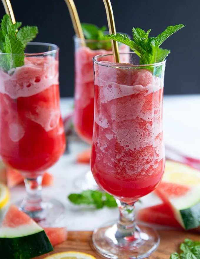 one cup of watermelon slushie close up showing the frozen and soft parts of the slushie