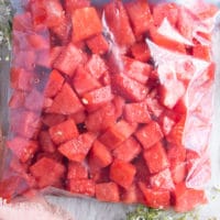 watermelon cubes placed in a ziploc bag and ready to freeze