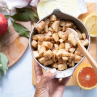 A bowl with the apple crumble filling ready and tossed together