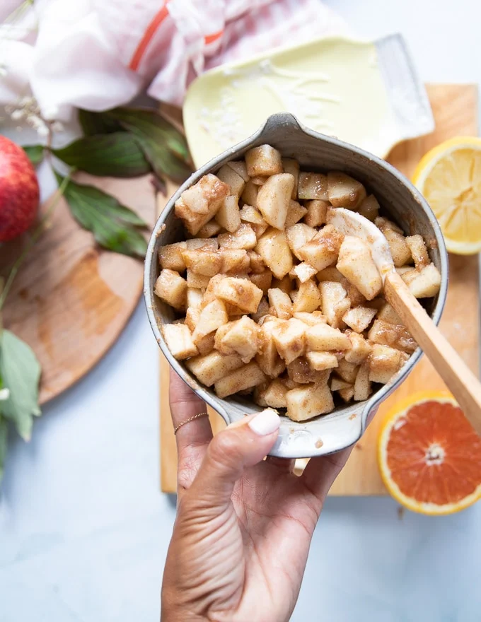 A bowl with the apple crumble filling ready and tossed together