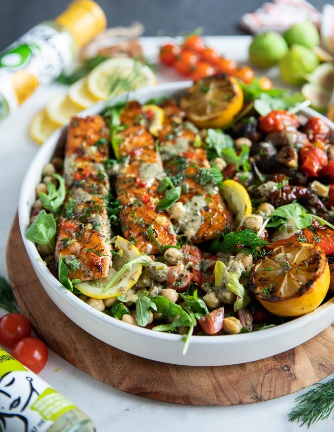 close up of a grilled salmon recipe on a plate with other grilled veggies