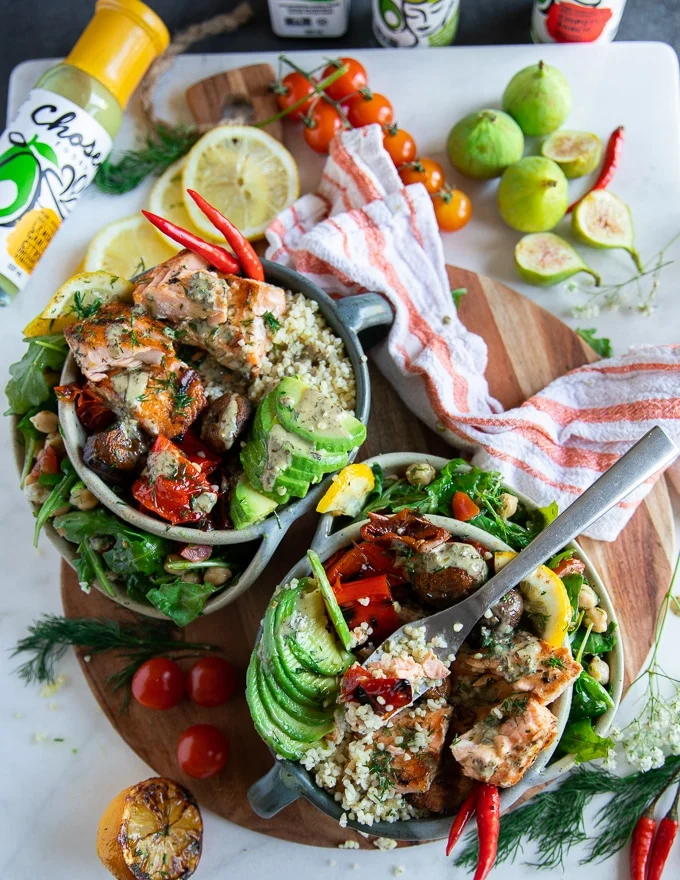 A fork dipped into a bowl of grilled salmon salad